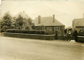 Clara Udall (nee Yeomans) at the gate of Apsley Sweetpool Lane in about 1930.  Clara had 10 children during her life.